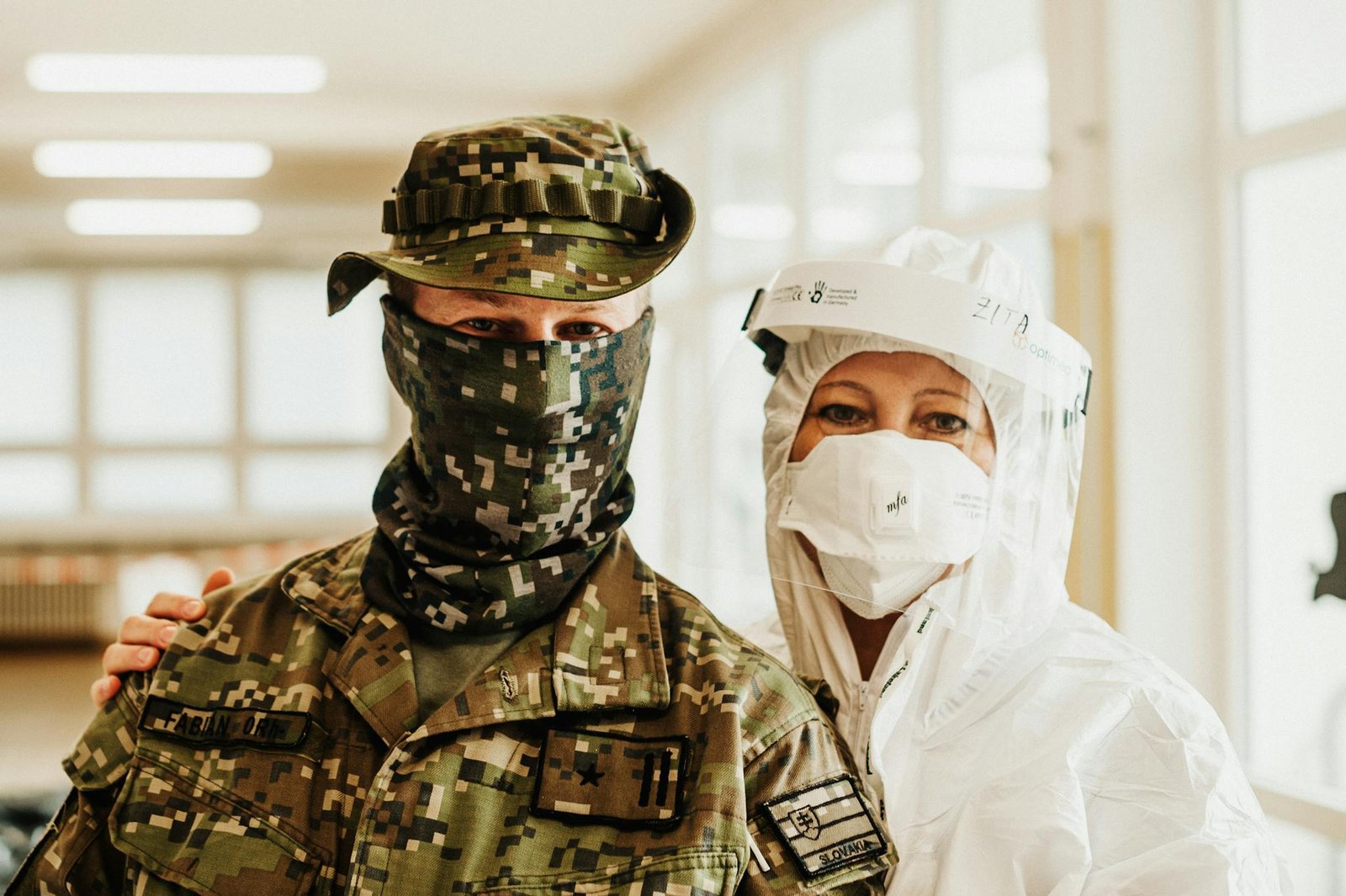 A soldier and healthcare worker wearing PPE, symbolizing teamwork during the pandemic.